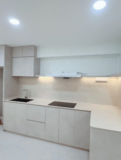 After: the same galley kitchen rebuilt in matt cream handleless carpentry with a concealed hood and induction hob.