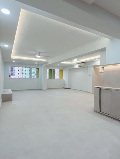 After: the same room opened up, with a cove-lit recessed ceiling panel and a pale poured floor.