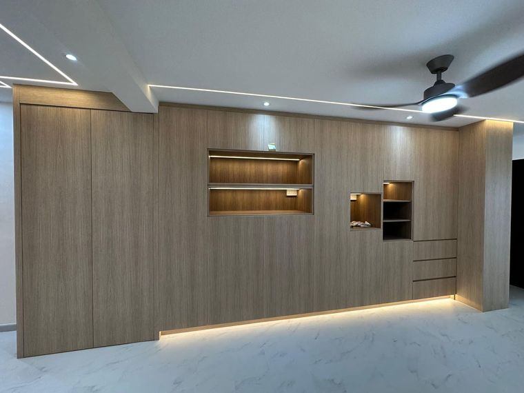 Full-height oak-veneer carpentry wall in a living room, with concealed doors and two LED-lit display recesses.